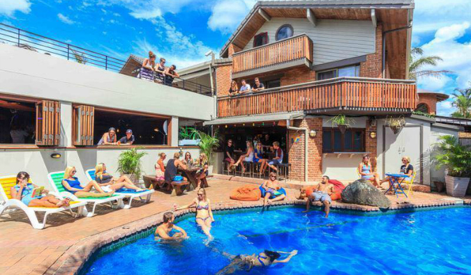 在澳大利亚拜伦湾的水瓶座背包客酒店，人们在泳池里游泳或在泳池边闲逛。