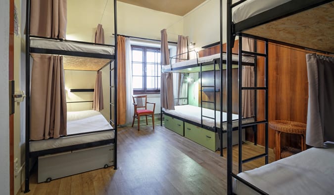 3 wrought iron bunk beds in a minimally decorated dorm room at Little Quarter in Prague