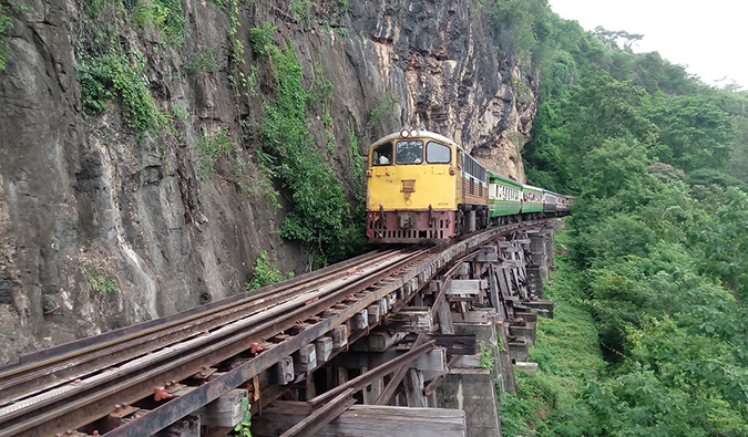 在泰国北碧，一列紧靠悬崖边的火车