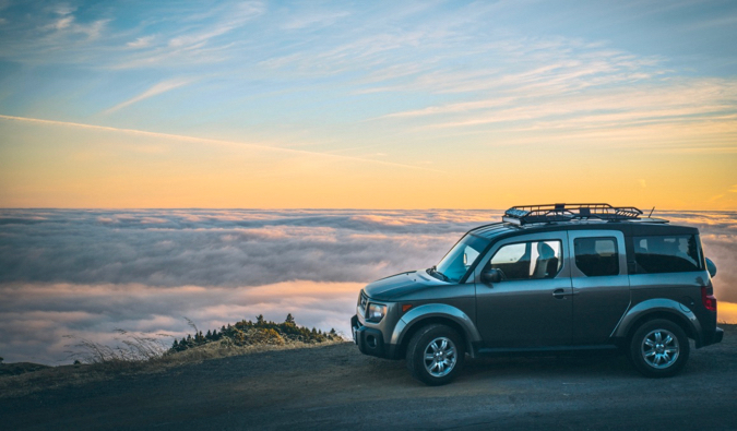 一辆出租的汽车停在一个被云包围的美丽景色附近