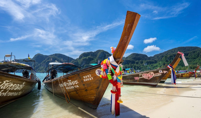 Koh Phi Phi的长尾船停在泰国湛蓝的天空前的沙滩上