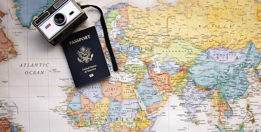 一张世界地图，上面放着照相机和护照