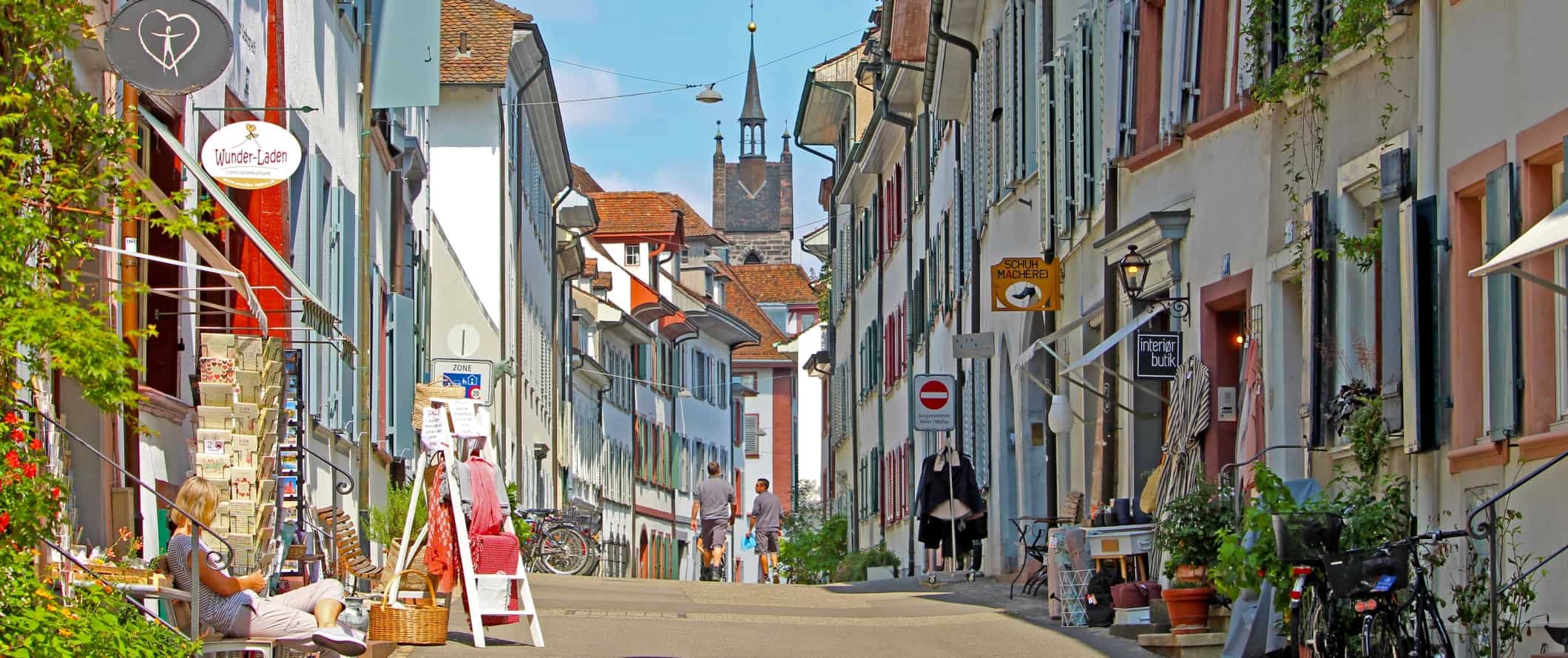 在瑞士巴塞尔的历史中心，一条街道两旁是白色建筑和色彩鲜艳的百叶窗