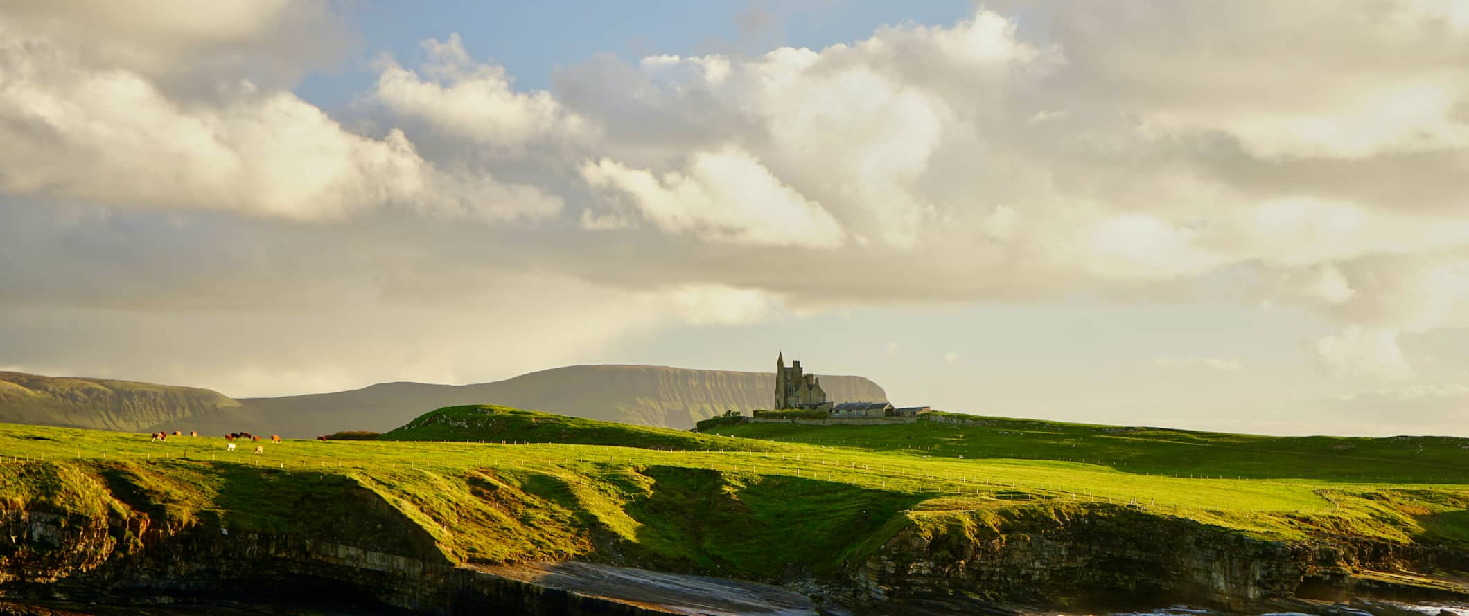 爱尔兰乡村的一座城堡，四周环绕着连绵起伏的绿色田野