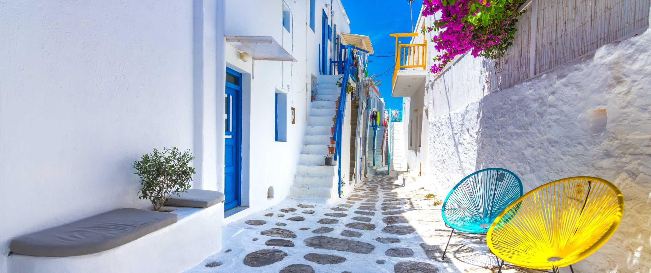 希腊米科诺斯岛的米科诺斯老城区的街道，白色建筑和蓝色门窗。