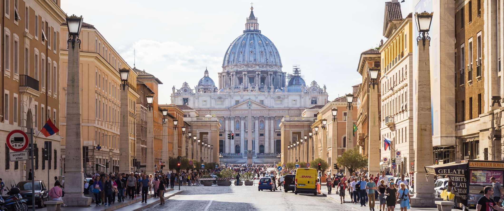 在意大利罗马，宽阔的街道上挤满了人，尽头是长方形教堂