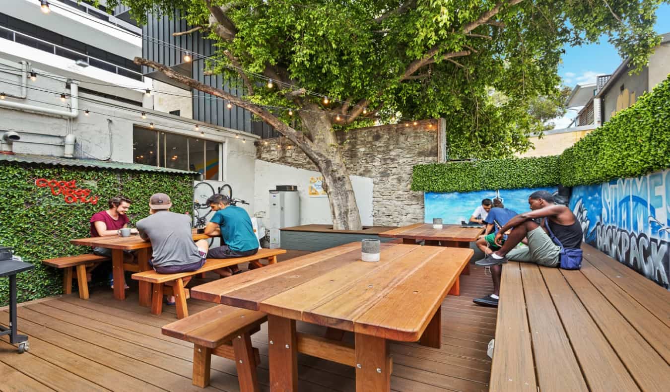 悉尼避暑屋背包客旅馆的户外庭院里有木制野餐桌和长凳