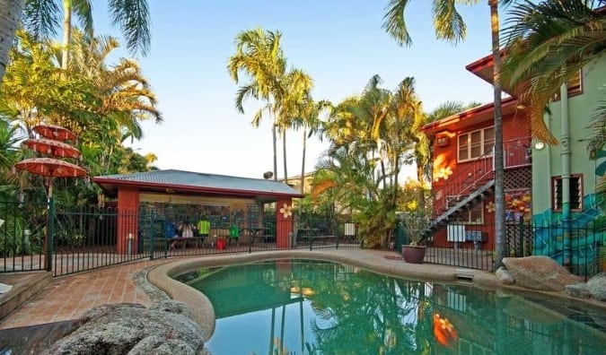 澳大利亚凯恩斯旅行者绿洲旅馆的室外游泳池被棕榈树环绕。