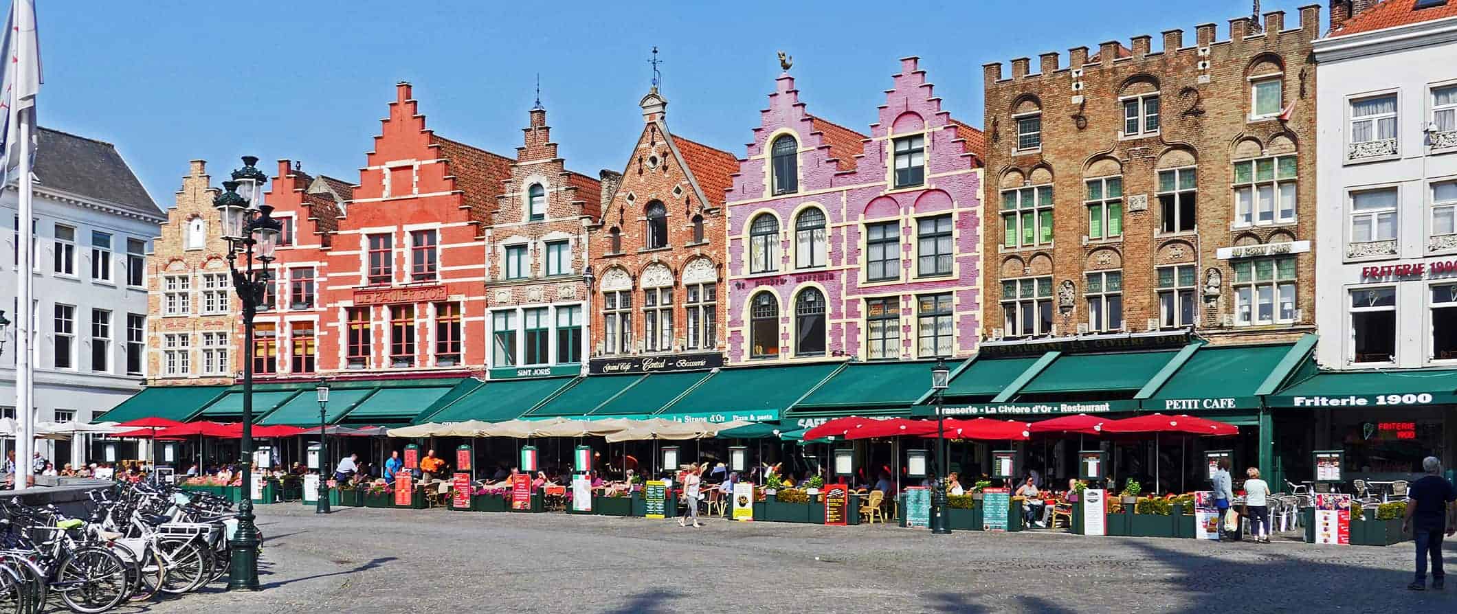 比利时布鲁日，一条由一排排老房子组成的色彩缤纷的街道，靠近一个挤满人的广场