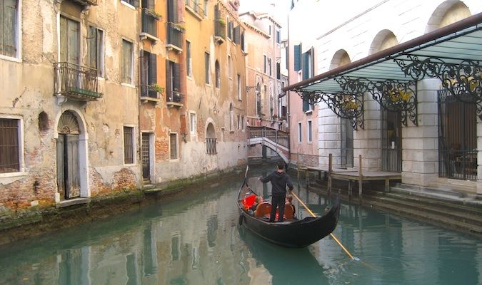 华丽的贡多拉与游客在威尼斯运河，意大利