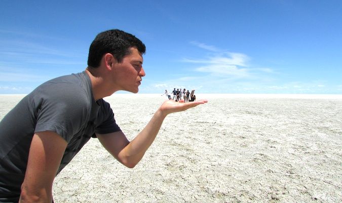 游牧的马特和他的朋友们在盐滩上摆出游客的姿势