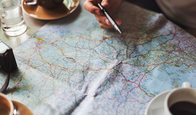 A person planning a Backpacking Trip to Europe with a map