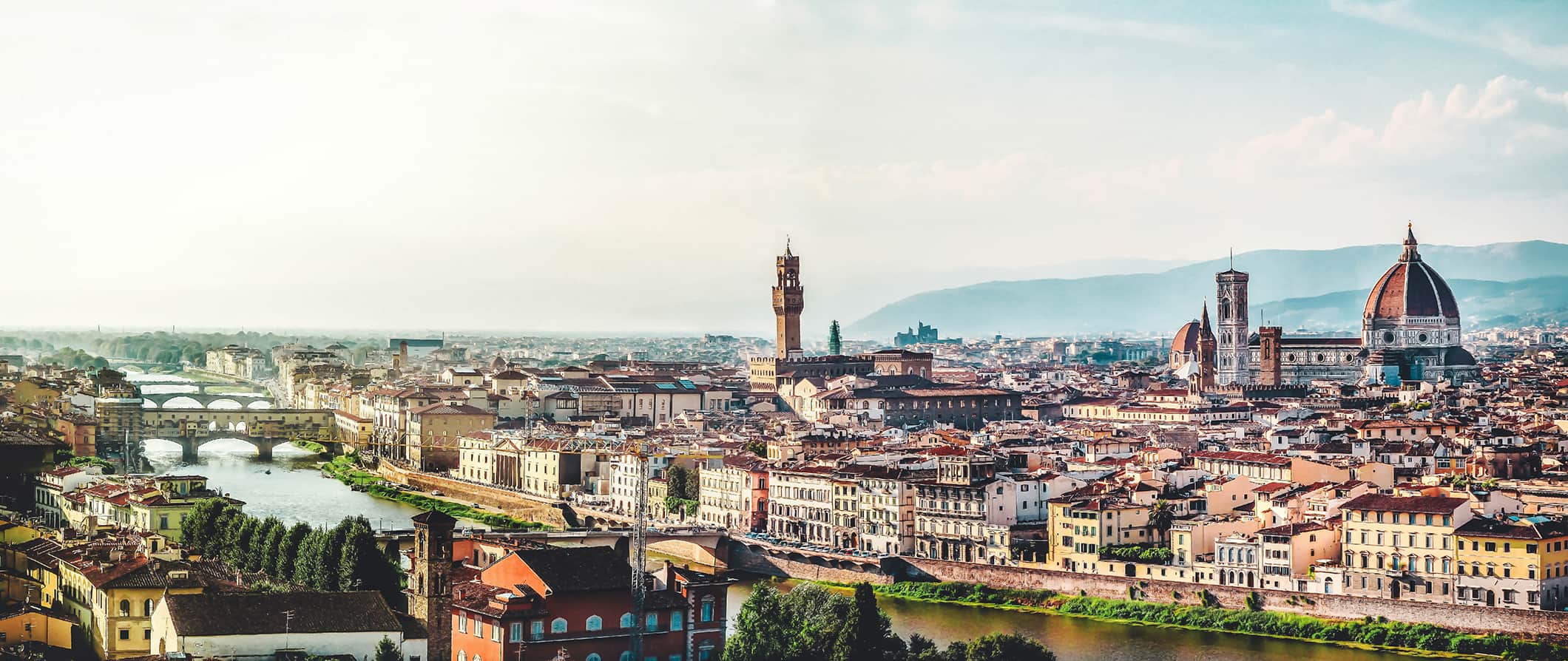 俯瞰意大利佛罗伦萨市的美丽景色，背景是令人惊叹的红色屋顶和山脉