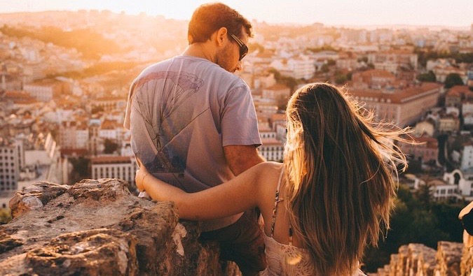 a couple watching the sunset as they overlook a city in Europe