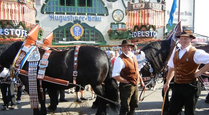 人们穿着传统的巴伐利亚服装，在啤酒节上站着我的马