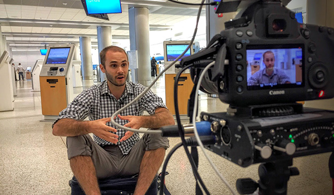 Scott filming a television interview at an empty airport