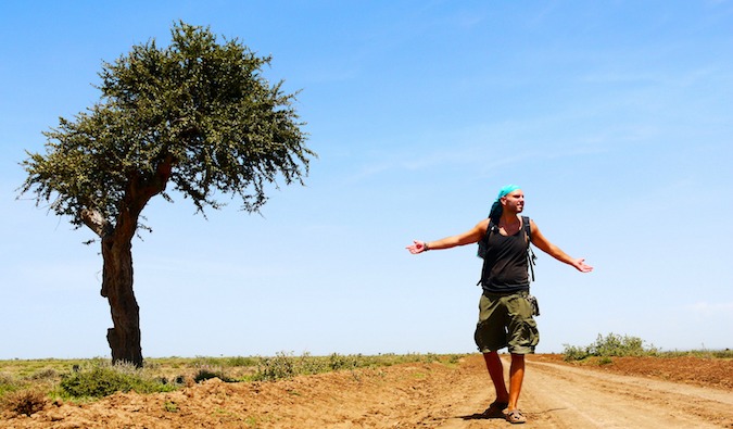 Tomislav是一名旅行博主和穷游者，他站在非洲坦桑尼亚的一棵孤独的树旁