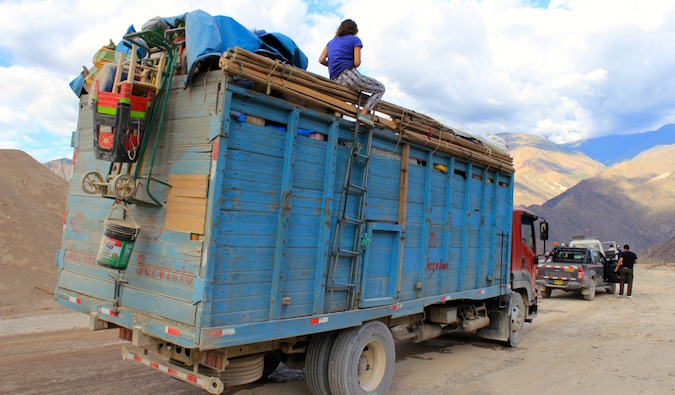 秘鲁一名背包客在一辆卡车上搭便车