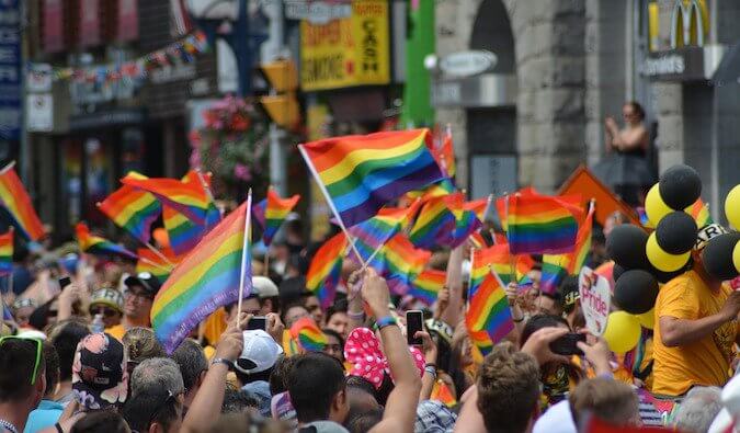 一群人在一个骄傲事件的街道上挥舞着彩虹旗
