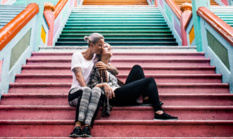 两个女同性恋旅游博主在亚洲的一组彩色楼梯前摆姿势