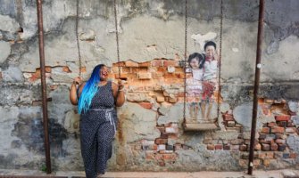 安妮特在槟城的一幅壁画旁摆姿势
