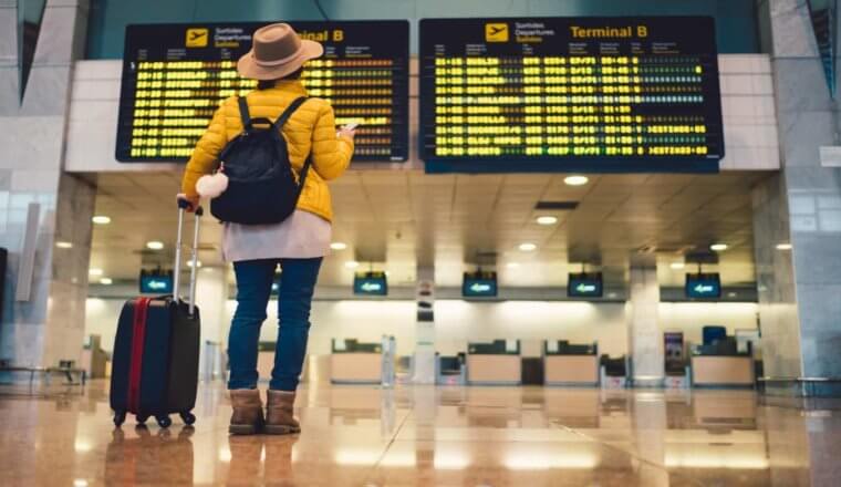 在巴塞罗那机场，一名女子站在航班登机牌前