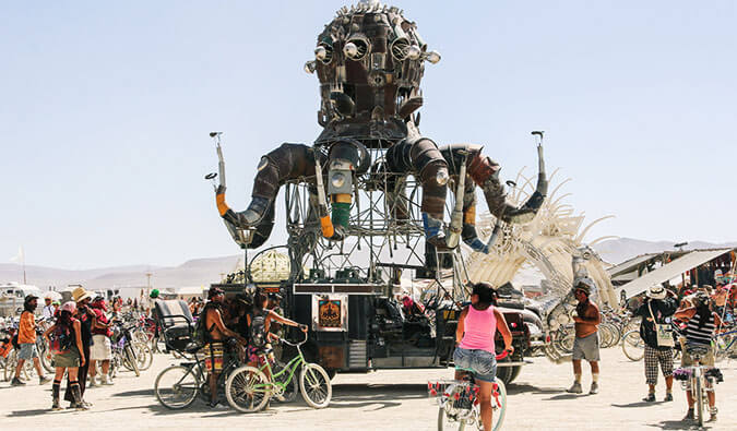 人们骑着自行车在火人节的巨型雕塑周围