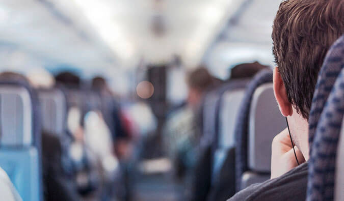 一名戴着耳机的男子坐在飞机上