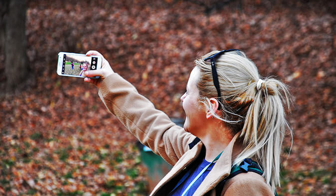 森林的妇女采取与她的巧妙的电话的一个selfy