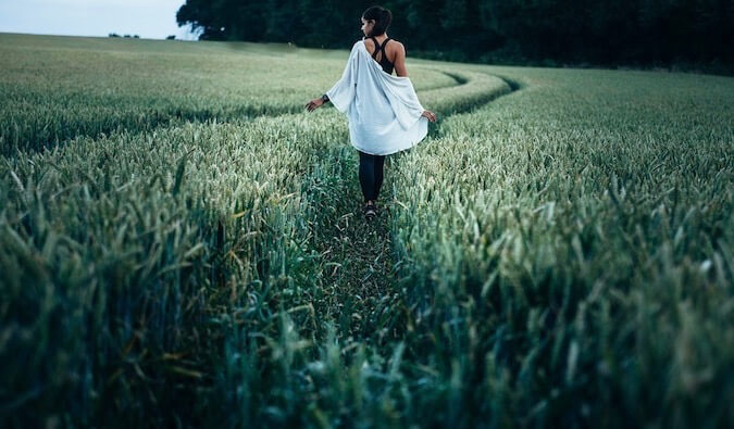 一个女人独自走在高高的草地上