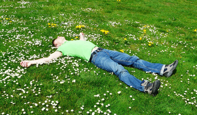 一个人躺在长满雏菊的草地上