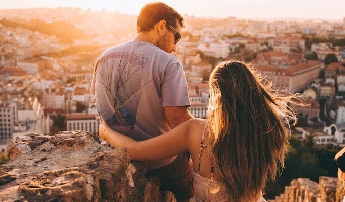 在欧洲的一个城市，一对情侣在看日落时拥抱在一起