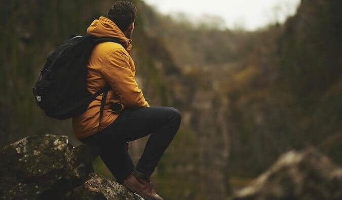 一个穿着黄色外套的人在群山的上方眺望