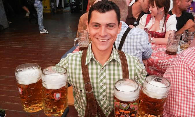 游牧的马特在十月啤酒节穿着传统的衣服拿着4品脱啤酒