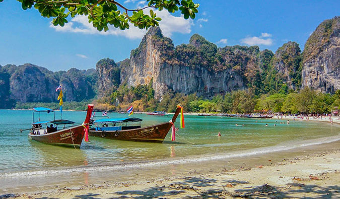 五颜六色的长船停泊在泰国的海滩上