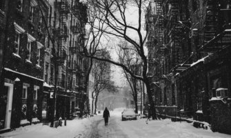 在纽约，一个人走在雪地里的黑白照片