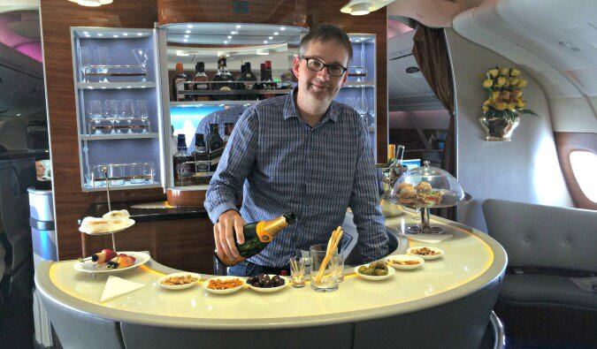 一名男子站在阿联酋航空头等舱的酒吧后倒香槟。