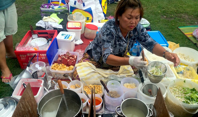 一名妇女服务在泰国食物市场的食物在柏林