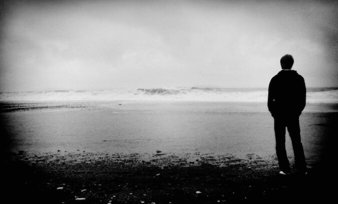 一张黑白照片，一个男人俯瞰着一个湖