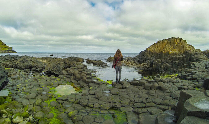 看美丽的岩石冰岛风景的独奏女孩旅客