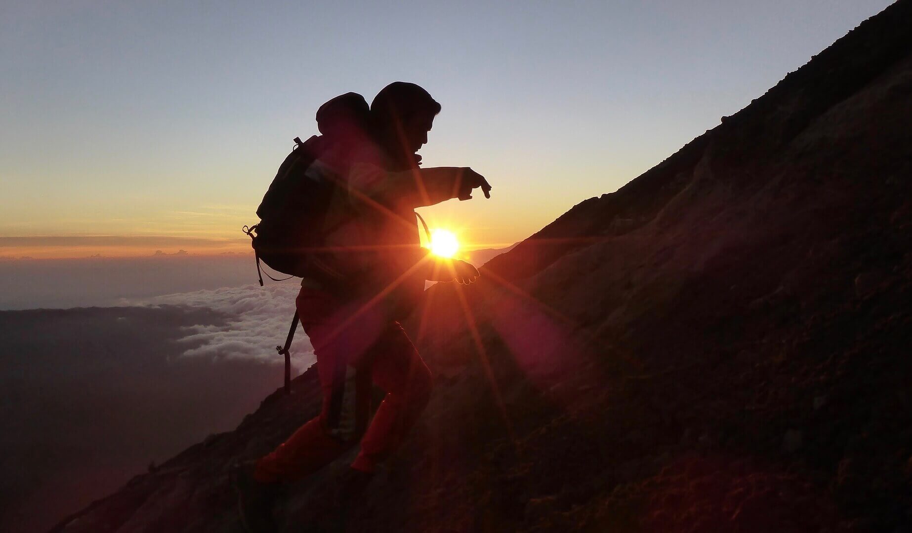 一个人在日落时爬山