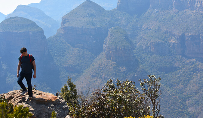 游牧的马特站在岩石上向下看。在他的后面是山