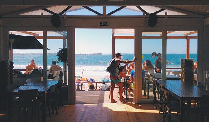 空荡荡的餐厅望向海滩，背景中有人在露台上吃东西
