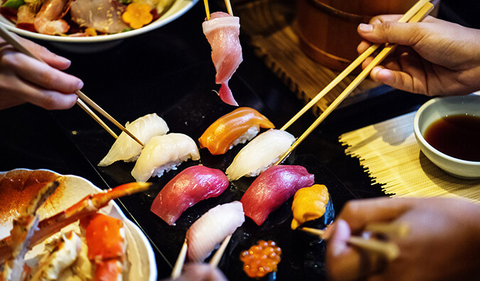 在东京，人们用筷子吃寿司
