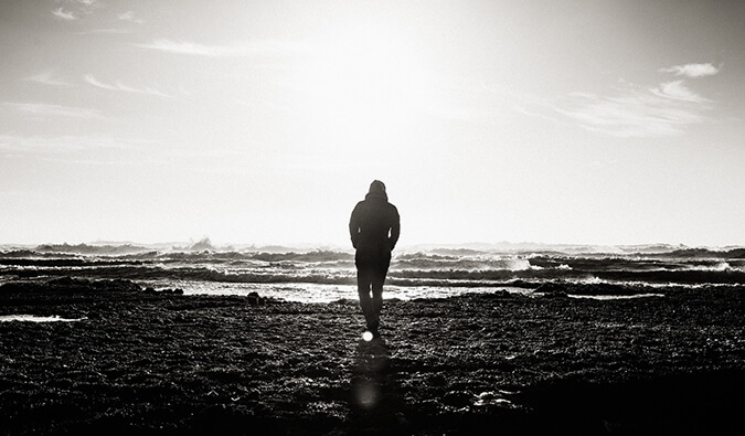 单独走在海滩的人。图像是黑色和白色