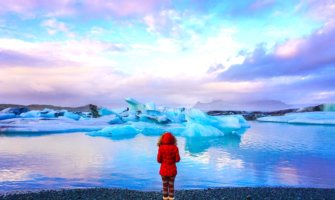 在冰岛的冰川泻湖，穿着阅读外套的女性独自旅行者