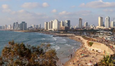 the beach in Tel Aviv with skyscrapers in the background