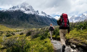 一个徒步旅行者走在通往雪山的小径上