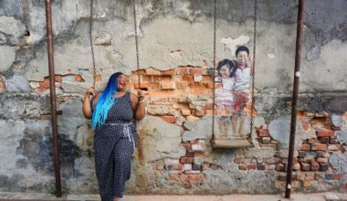 安妮特在槟榔屿的一幅壁画旁摆姿势