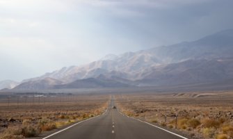 一辆汽车行驶在美国死亡谷的开阔道路上